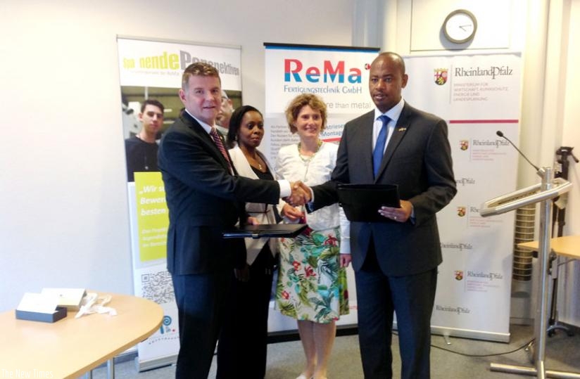 Nsengiyumva exchanges documents with Rudolphi after signing the TVET deal as Amb. Nkulikiyinka and Lemke look on. (Courtesy)