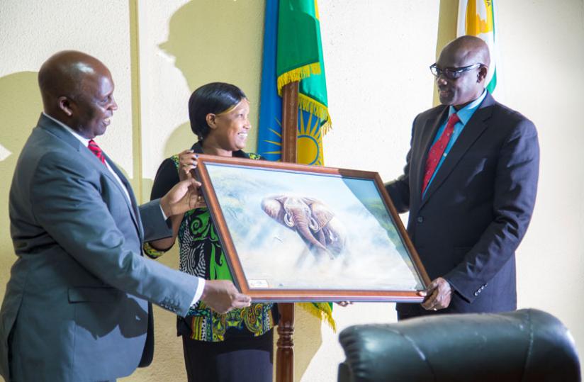 Busingye (R) receives a painting of an elephant from the  Power of Mercy Advisory Committee members of Kenya. (Doreen Umutesi)