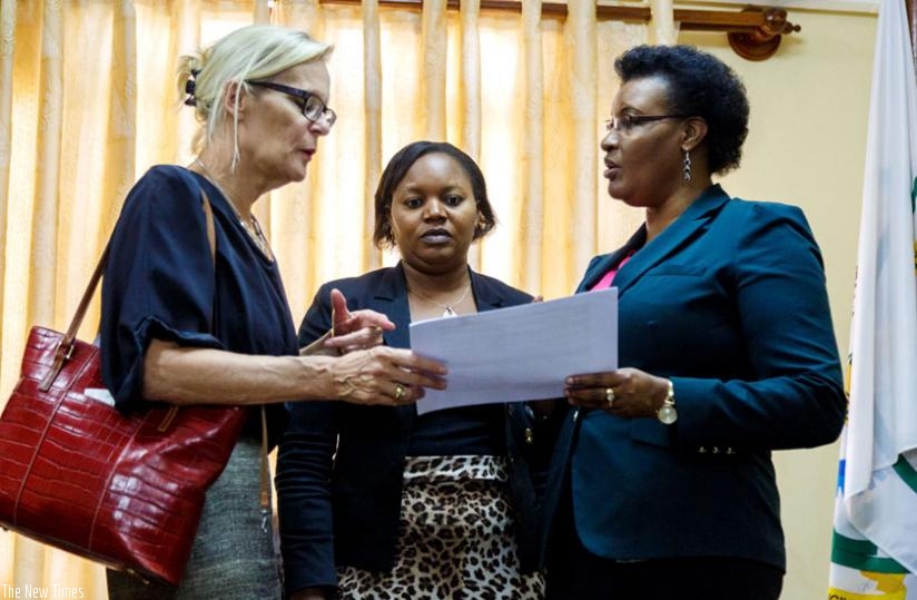 Amb. Cuelenaere (L) Deputy Speaker Jeanne d'Arc Uwimanimpaye (C) and Speaker Mukabalisa go through documents at Parliament yesterday.(Timothy Kisambira)