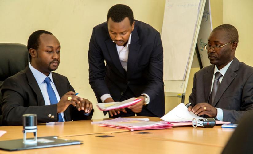 Mineral economist Joseph Butera (C) presents paperwork to Minister Evode Imena (L) to sign as Emmanuel Nyabyenda of SEAVMC Ltd prepares to sign his part of the agreement. (Doreen Umutesi)