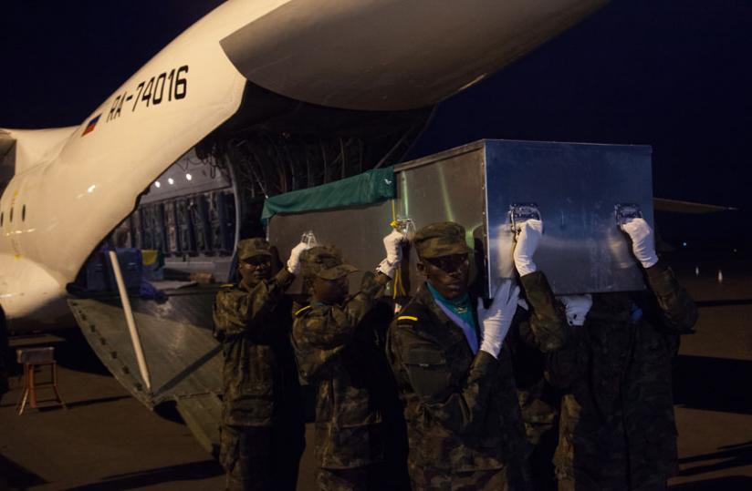 A casket containing the body of one of the fallen peacekeepers is carried from a UN plane. (Photos by Faustin Niyigena)