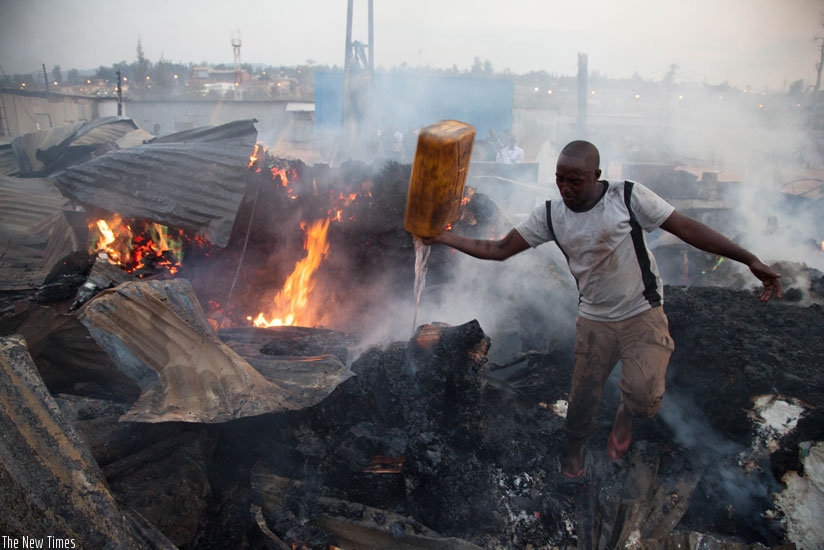 A resident in Gikondo fights to stop fire in July last year. (Timothy Kisambira)