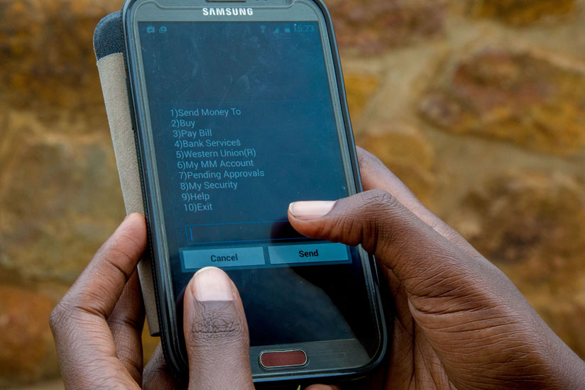 A customer uses mobile money service to make a transaction. This has been used as one of the strategies to boost financial inclusion. (File)