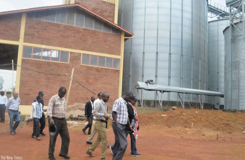 Mukeshimana  (putting on a cap) and other ministry officials after touring the new storage facility.  (P. Tumwebaze)