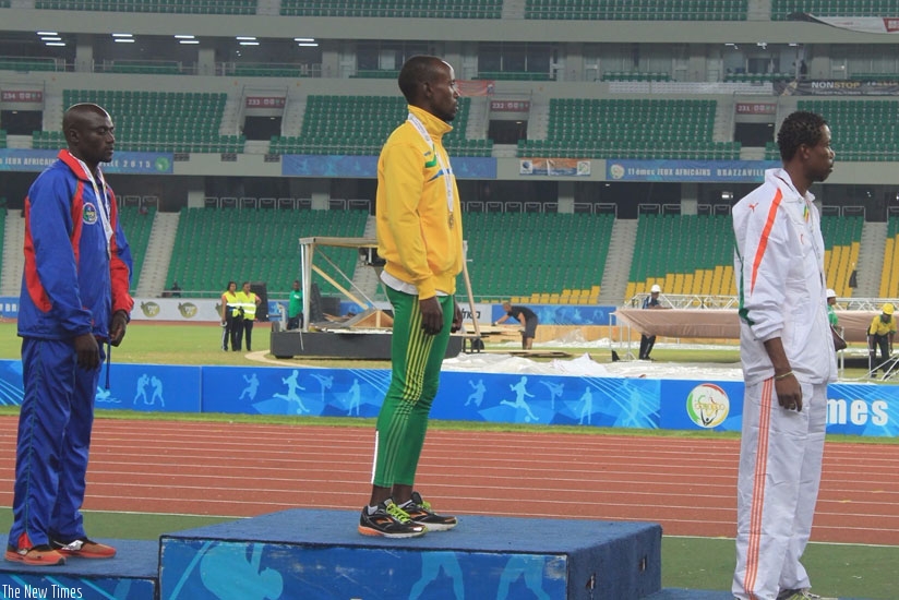 Gold medalist Muvunyi (center) on podium singing the national anthem in a 60.000 sitter new Kintele stadium. (Courtesy)