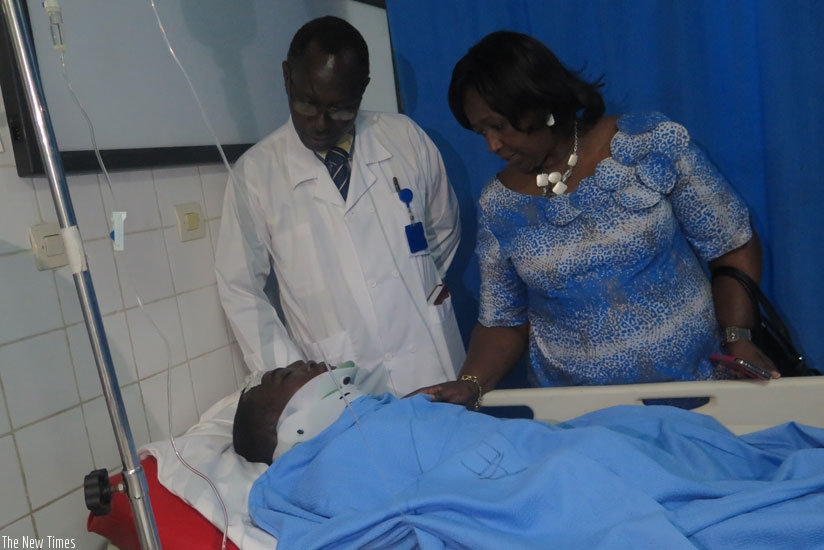 Minister of Health Dr. Agnes Binagwaho (R) and CHUK Direcfor, Dr. Theobald Hategekimana check on Etienne Nsanzimana who was injured in the accident yesterday (Jean Mugabo)