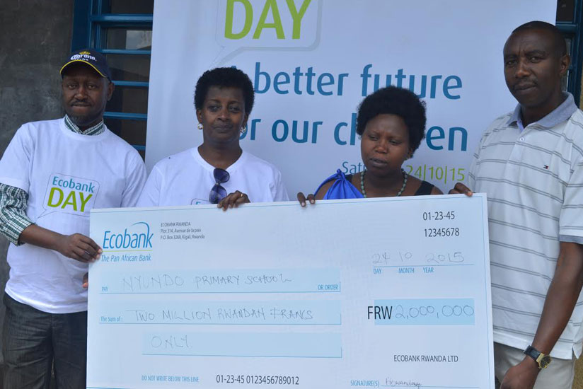 Ecobank's Barbara Bwandinga (second left), Collette Mutuyimana, the headmistress of Nyundo Primary School (second right) and Francois Xavier Mbabazi, the mayor of Ruhango district (right) hold the dummy cheque. (All photos by Geoffrey Wakiibi)