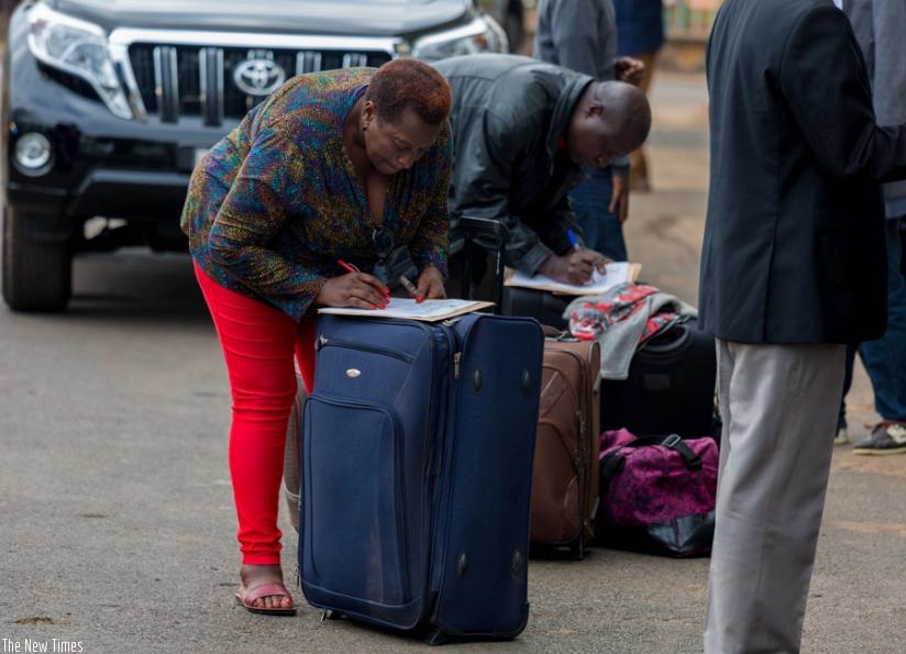 Itorero instructors sign documents at Petite Stade in Remera before departure. (T. Kisambira)