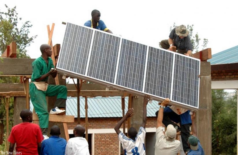 Workers instal a solar panel on a building in Kigali. (File)