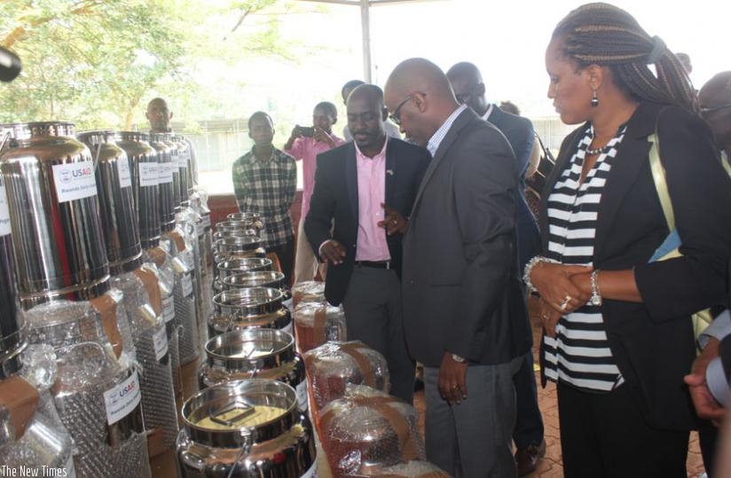 Karamuzi(L) and other officials inspect the dairy equipment donated by USAID. (John Mbaraga)