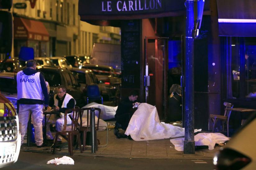 Victims lay on the pavement at a Paris restaurant on Friday. Dozens of people were killed in multiple shootings and explosions in the city, according to police. Police also said there was a hostage crisis taking place in a concert hall. (Net photos)