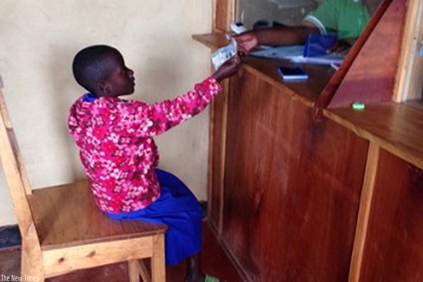 A child saver banks her savings at a SACCO. To grow savings, one needs a deliberate plan. (File)