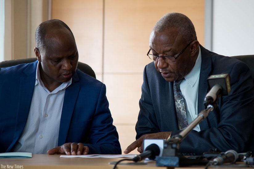 Charles Munyaneza, the executive secretary of the National Electoral Commission (L) chats with  Kalisa Mbanda, the chairperson during the media briefing. (Timothy Kisambira)