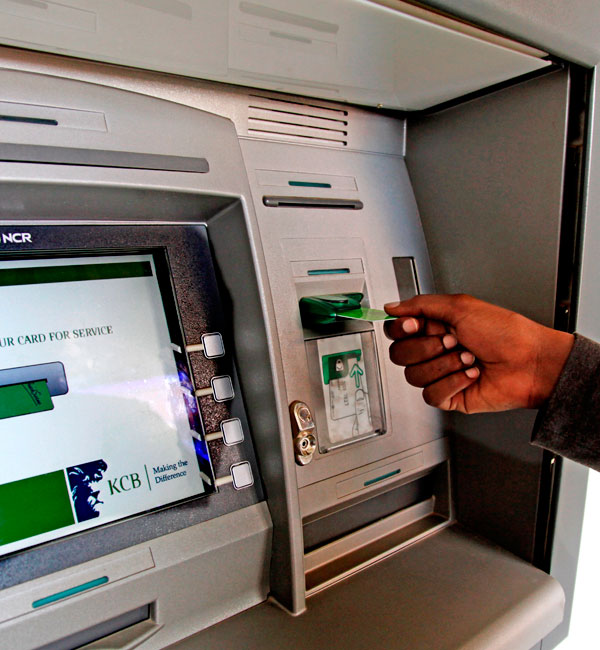 A client withdraws money from an ATM machine. (Timothy Kisambira)