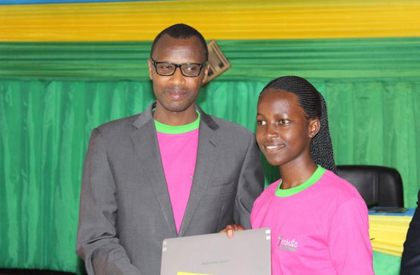 One of the girls who performed well in last year's National exams recieving a Laptop from Education Minister Papias Musafiri. (M. Nkurunziza)
