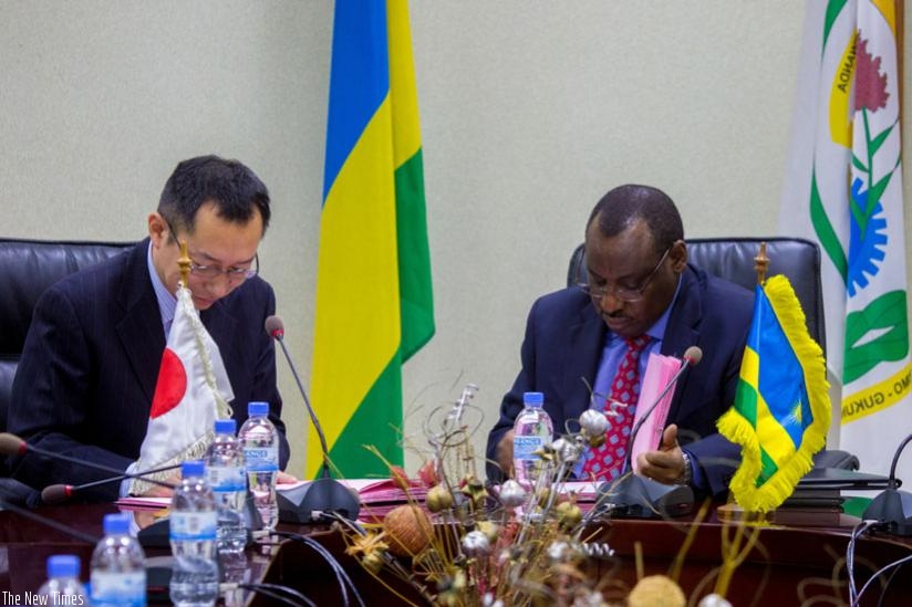 Takahiro Moriya, the chief representative of the Japan International Cooperation (L) signs documents with Finance minister, Claver Gatete (T. Kisambira)