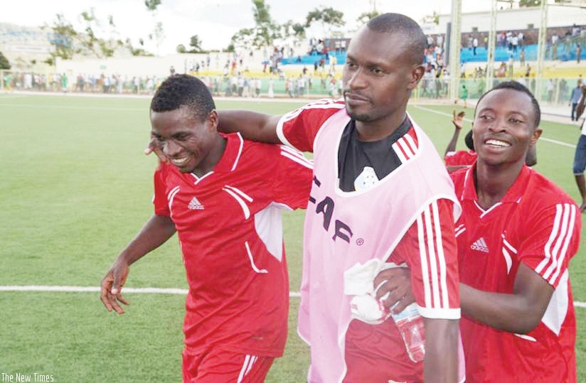 Etincelles coach Innocent Seninga in a light moment with his players after beating APR FC 1-0 in a league fixture on April 21. (File)