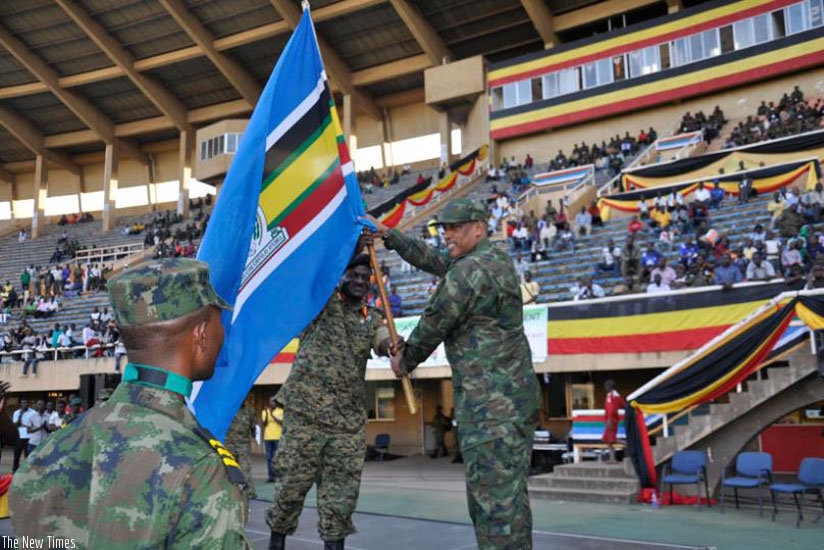 RDF Chief of Defence Staff, Gen Patrick Nyamvumba, receives the EAC flag from his Ugandan counterpart Gen Edward Katumba Wamala (L) at Namboole Stadium in Kampala. (File)