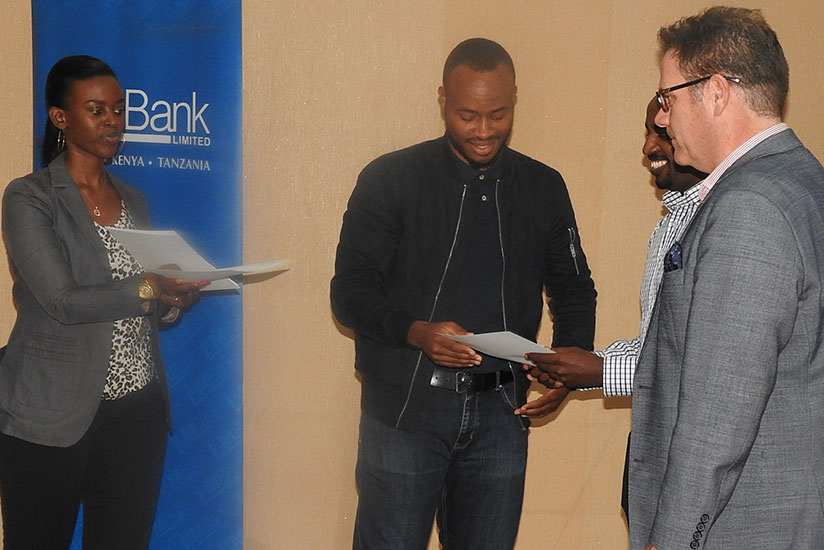 One of the trainees (middle) receives a certificate from Bairstow and other bank officials. / Appolonia Uwanziga