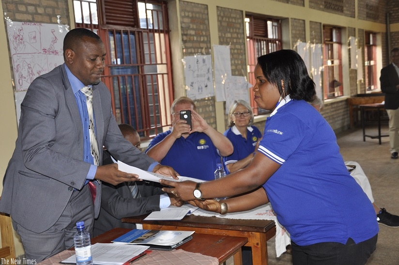 State Minister of Primary and Secondary Education Hon. Isaac Munyakazi awards certificate to trainers. (Kelly Rwamapera)