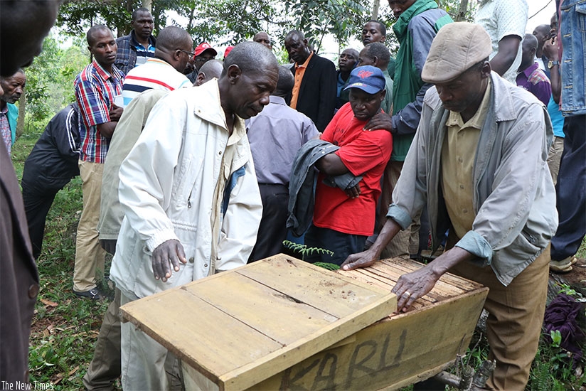 Members of Kauru coop demonstrate how bees enter hives. Michel Nkurunziza.