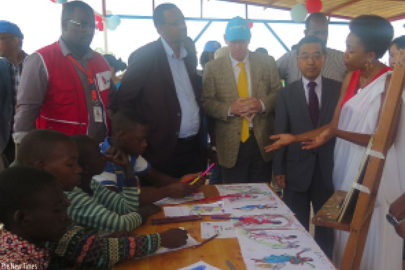 Ambassador Takayuki (2nd Right) and other officials inspect children  painting art work at Mahama Refugee Camp during their visit last week.   / Eddie Nsabimana.