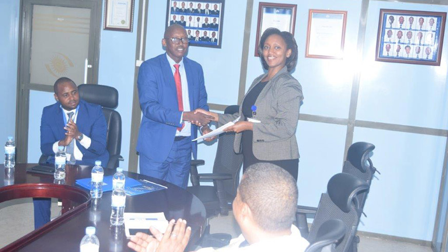 Makolo (R) shakes hands with Ndagano as State Minister Uwihanganye looks on. Courtesy.  