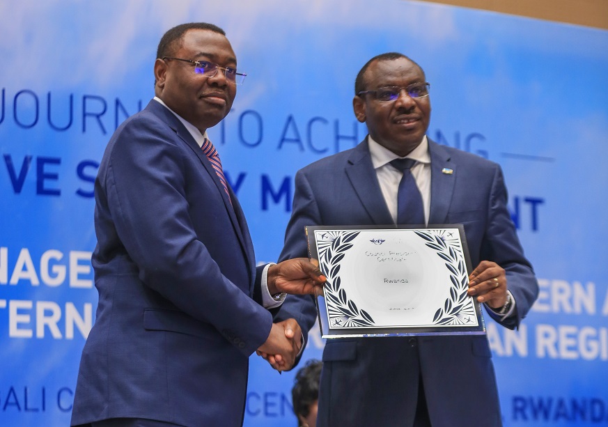 The President of ICAO Council, Dr. Olumuyiwa Benard Aliu, hands aviation safety certificate to Rwandaâ€™s Minister for Infrastructure, Claver Gatete during the ICAO regional safety symposium at the Kigali Convention Centre last week. 