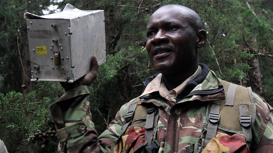 A security personnel carries an electric equipment from a single turboprop Cessna Caravan plane, operated by local firm FlySax, that crashed in a forested cliff in the Aberdare Range, in central Kenya yesterday. Net photo.