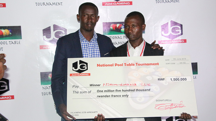 Elie Nshimiyimana (right) receives a dummy cheque of Rwf 1.5million after winning the championship on Saturday. (Courtesy)