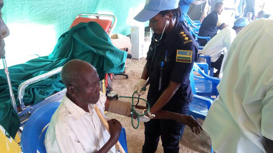 A Rwanda Police peacekeeper in CAR attends to an elderly during a medical outreach exercise.