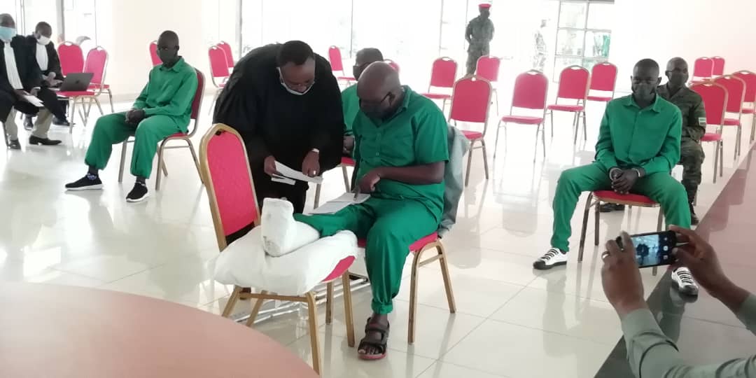 Mudathiru consults with his lawyer during the proceeding at the Military High Court. The suspects were spaced to conform to the Covid-19 measures and were all seen wearing face masks.