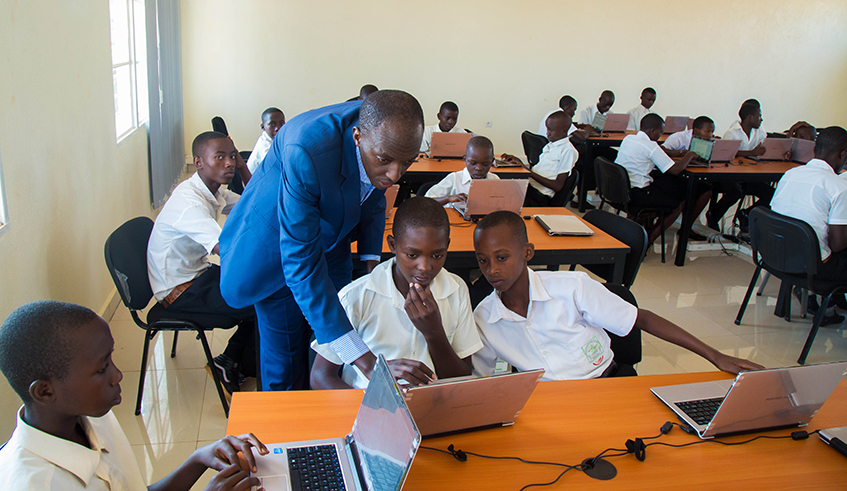 IT teacher helps students in a smart classroom at Groupe Scolaire Rweru in Bugesera District in 2016. / Photo: Sam Ngendahimana.